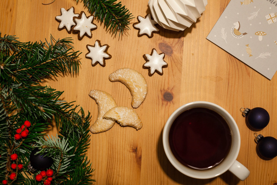 Tisch mit Keksen, Tasse und Weihnachtsdeko