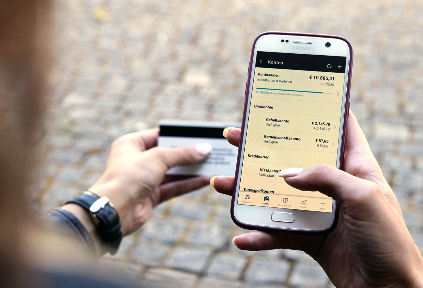 Frau macht Online-Banking auf dem Smartphone, daneben Kreditkarte