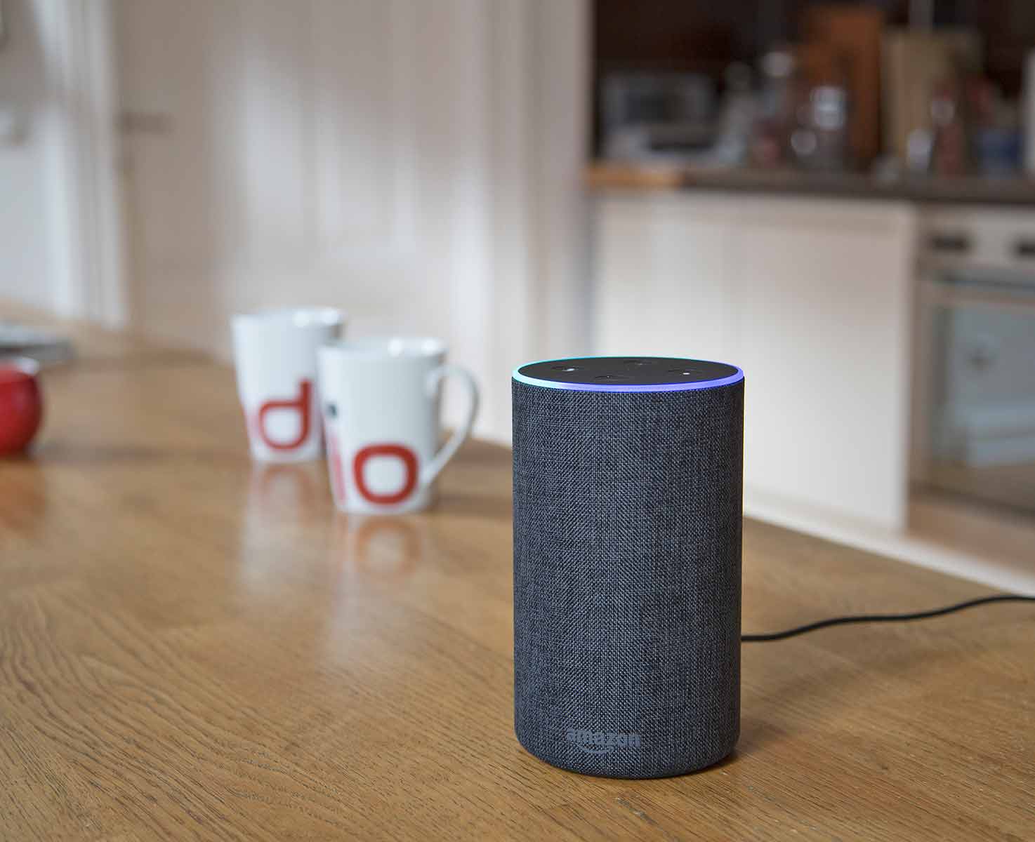 Amazon Alexa auf einem Tisch mit zwei Radio-Tassen im Hintergrund
